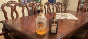 Two dusty unopened liquor bottles sitting on a surface, illustrating a personal story on consistency in leadership.